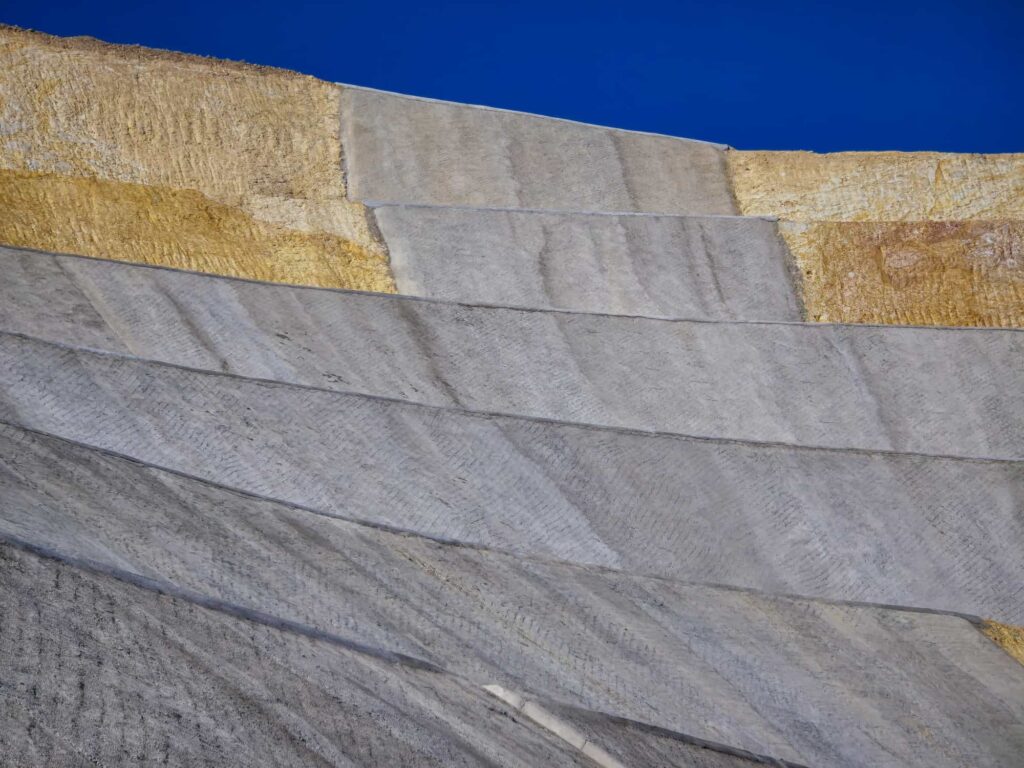 Erosion control blankets installed on a stepped slope to stabilize soil, reduce erosion, and support vegetation establishment.